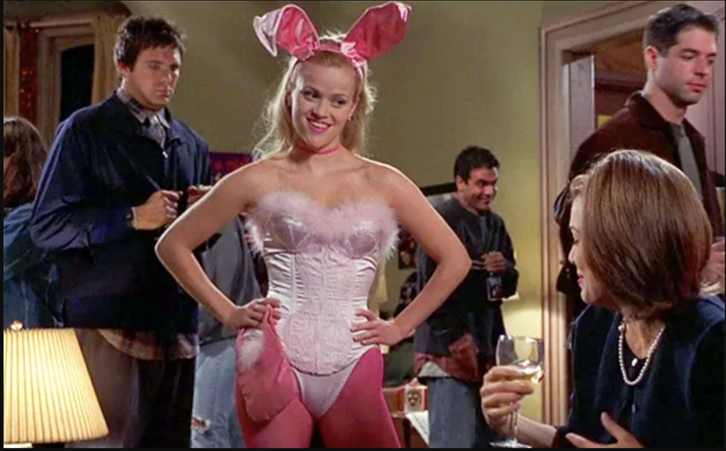 Reese Witherspoon as Elle Woods dressed as a cute pink bunny with a light pink bodysuit, bright pink tights and pink ears.