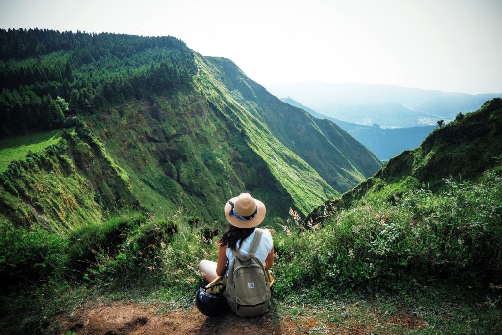 Backpaper/traveler admiring lush green mountains